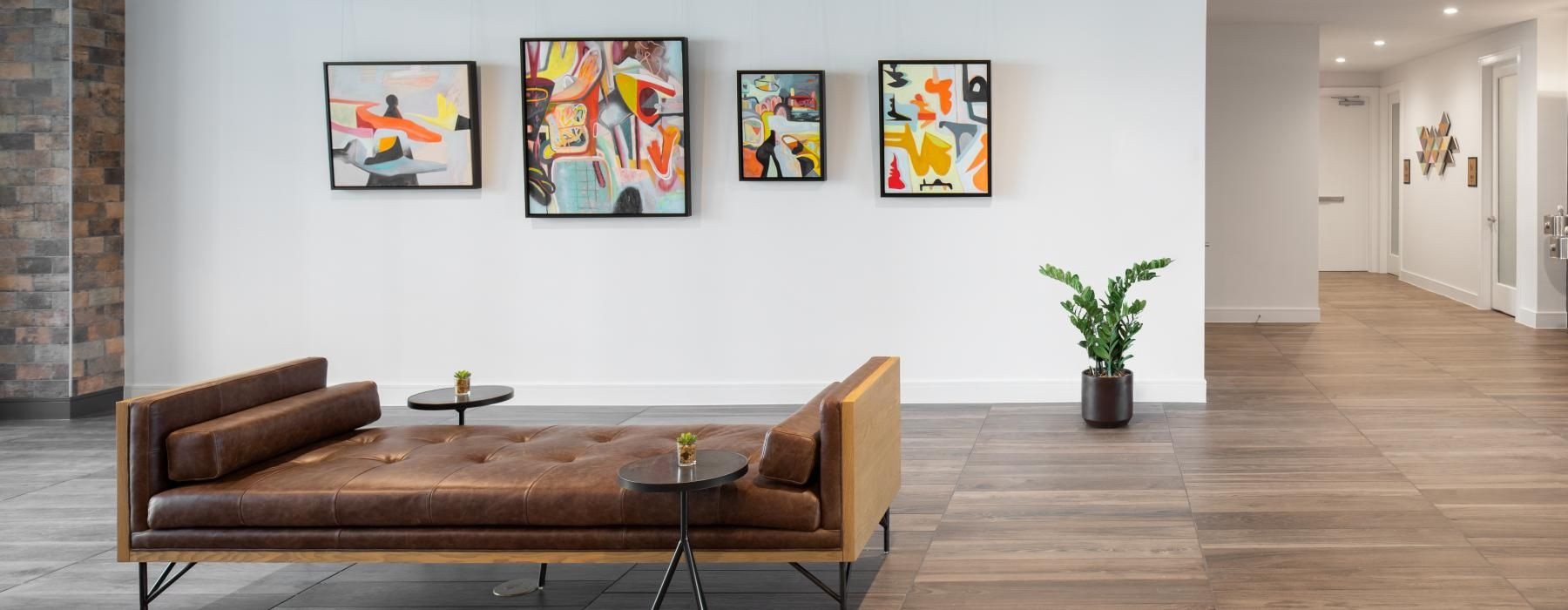 an art room with a couch and a table with paintings on the wall