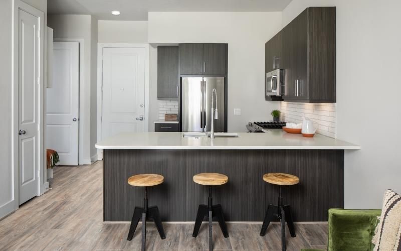 a kitchen with a bar and bar stools