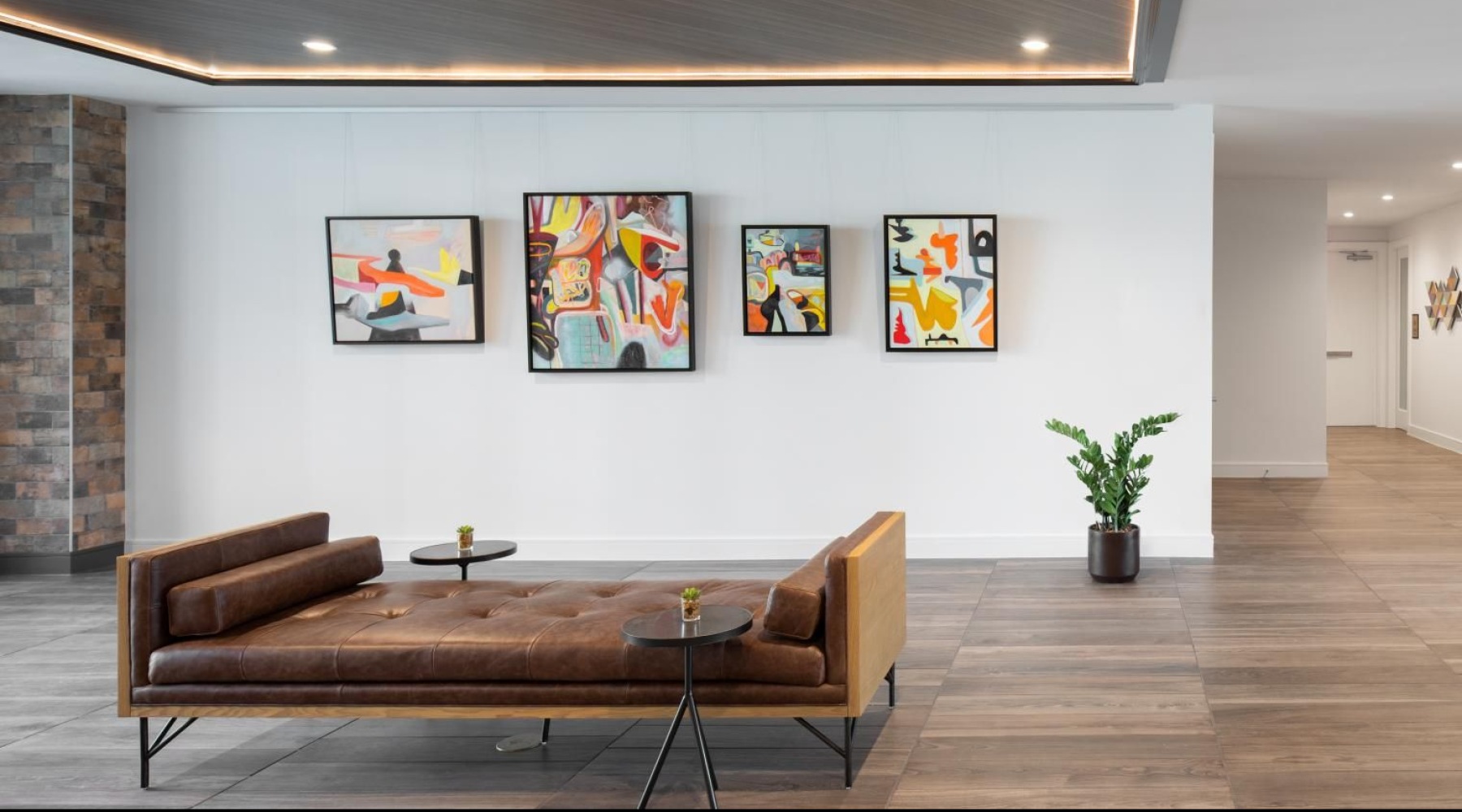 an art room with a couch and a table with paintings on the wall